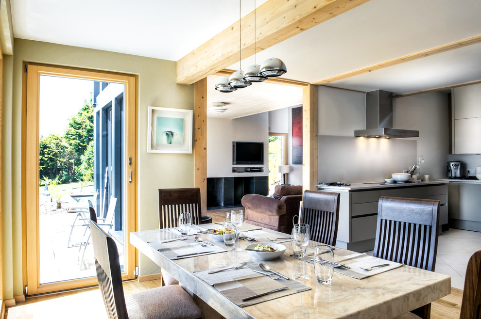 Idée de décoration pour une salle à manger ouverte sur la cuisine design avec un mur vert.