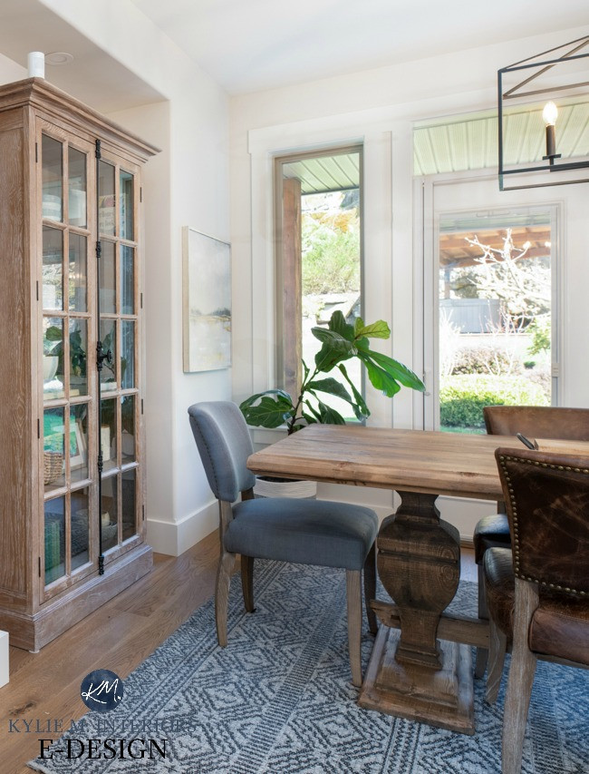 Exemple d'une salle à manger ouverte sur la cuisine chic de taille moyenne avec un mur gris, parquet clair et un sol marron.