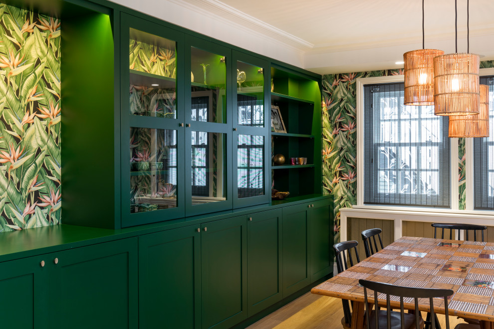 Idee per una sala da pranzo aperta verso la cucina tropicale di medie dimensioni con pareti verdi, pavimento in legno massello medio, pavimento marrone e carta da parati