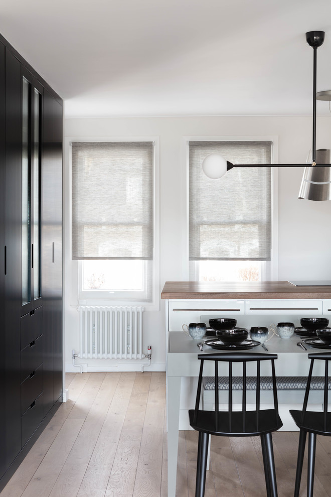 Imagen de comedor de cocina actual pequeño con paredes blancas, suelo de madera clara y suelo beige