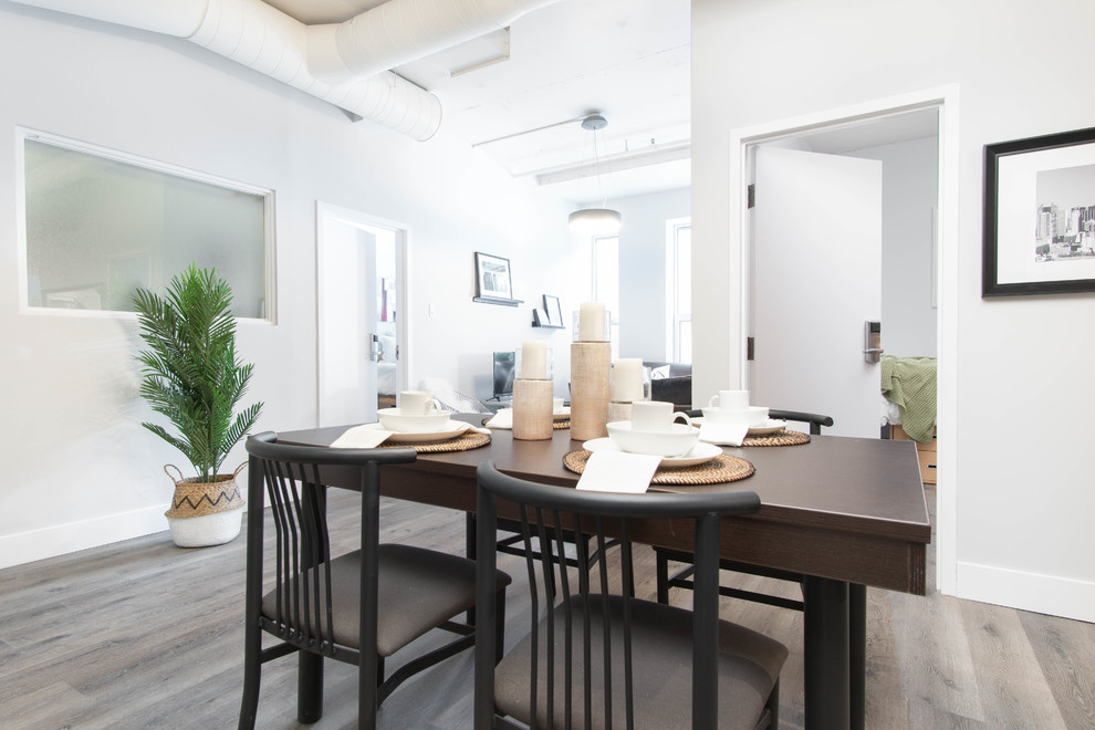 На фото: кухня-столовая среднего размера в современном стиле с белыми стенами, полом из ламината и серым полом с