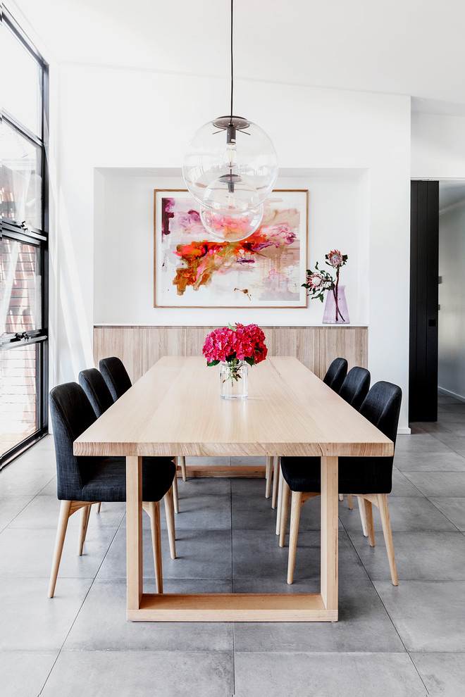 Cette photo montre une grande salle à manger ouverte sur le salon tendance avec un mur blanc, un sol en carrelage de céramique et un sol gris.