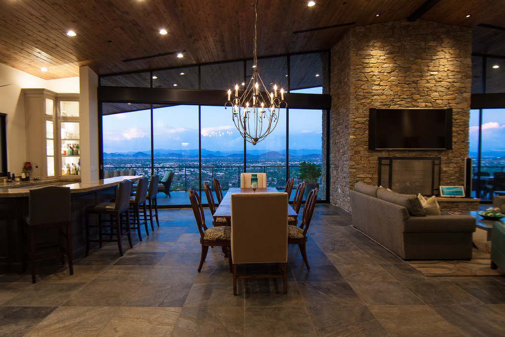 Стильный дизайн: огромная гостиная-столовая в стиле неоклассика (современная классика) с серыми стенами, полом из сланца, фасадом камина из камня и стандартным камином - последний тренд