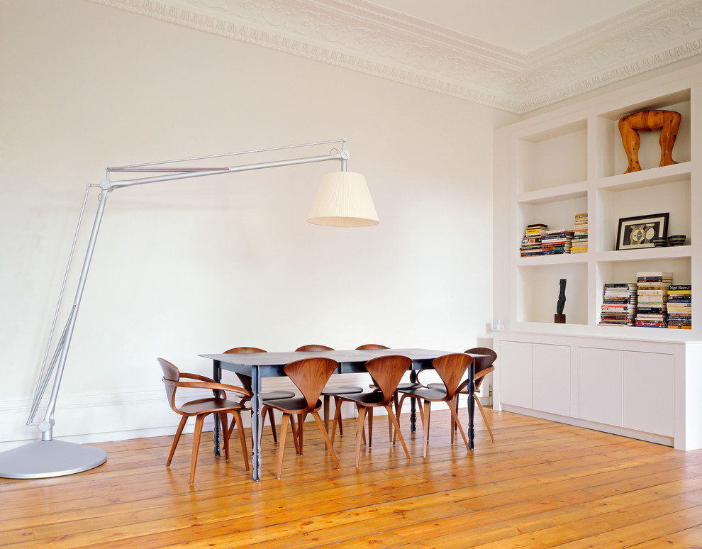 Immagine di una sala da pranzo scandinava chiusa con pareti bianche e parquet chiaro