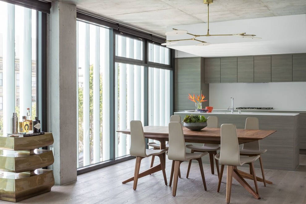 Cette photo montre une salle à manger ouverte sur la cuisine tendance avec un mur blanc et un sol en bois brun.