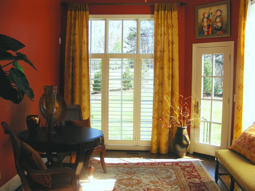 Klassische Wohnküche mit roter Wandfarbe und dunklem Holzboden in Sonstige