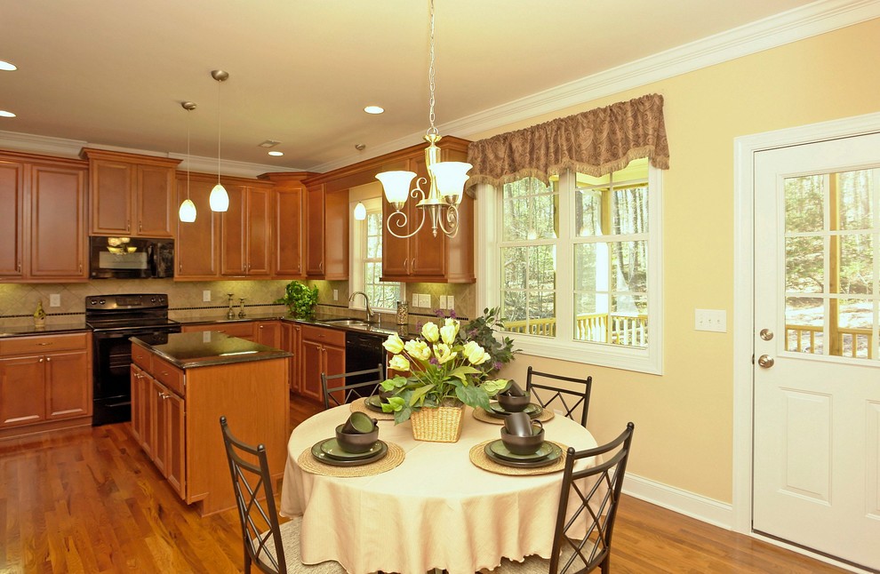 Immagine di una sala da pranzo aperta verso la cucina classica di medie dimensioni con pareti beige e parquet chiaro