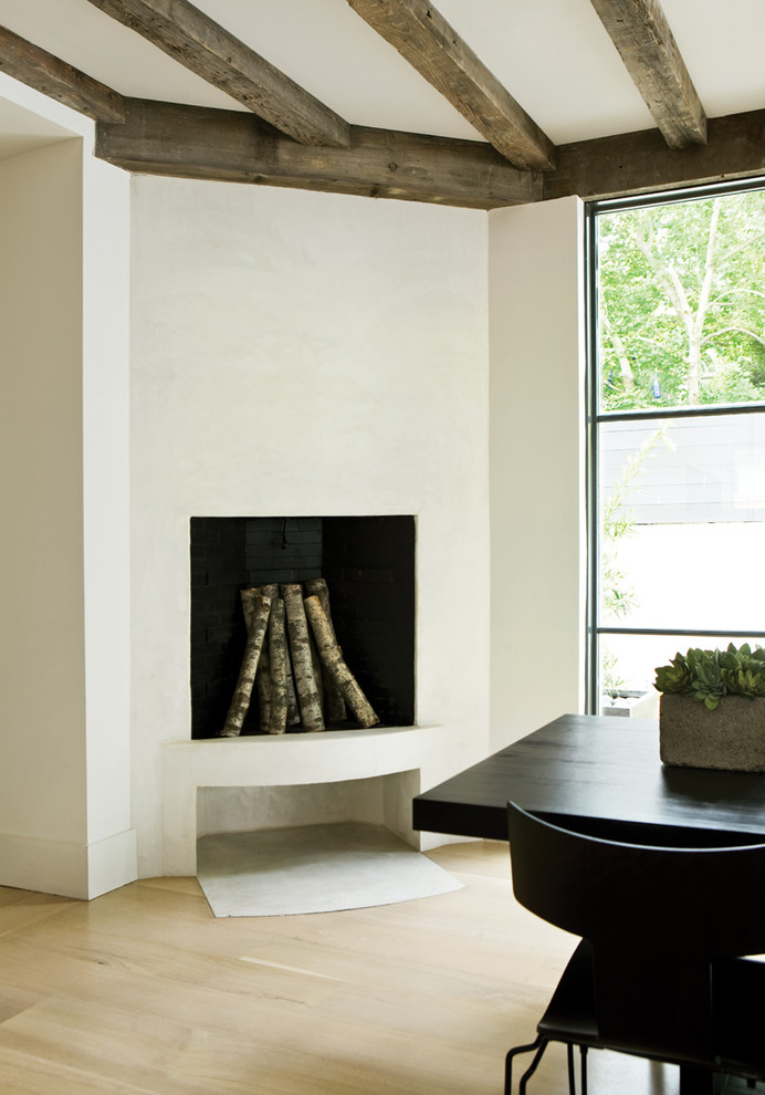 Стильный дизайн: столовая в стиле модернизм с белыми стенами, светлым паркетным полом и угловым камином - последний тренд