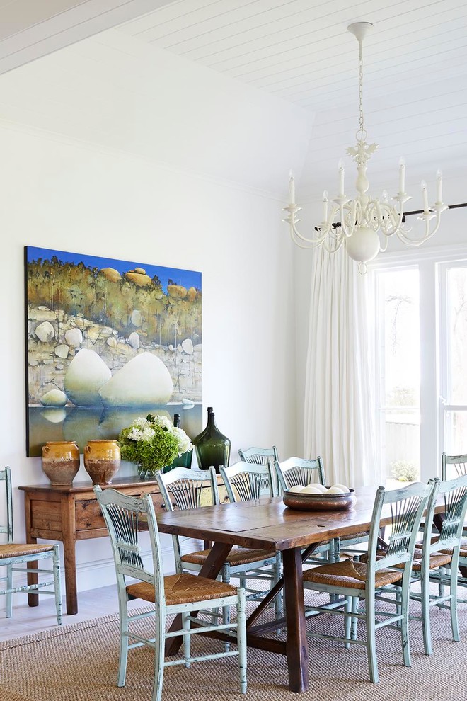 Foto di una sala da pranzo aperta verso il soggiorno tradizionale con pareti bianche e parquet chiaro