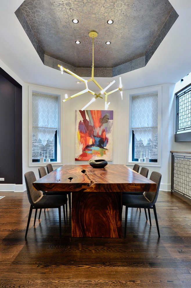 This is an example of a contemporary dining room in Chicago with white walls, dark hardwood flooring and brown floors.
