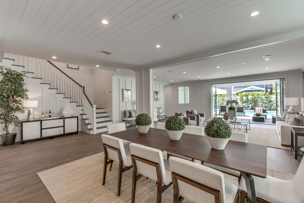 Idee per una grande sala da pranzo aperta verso la cucina design con pareti bianche, pavimento in legno massello medio e pavimento marrone
