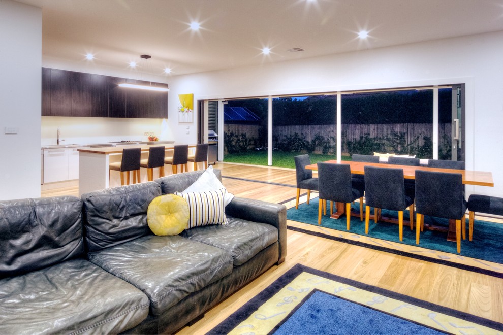 Offenes, Großes Modernes Esszimmer ohne Kamin mit weißer Wandfarbe und hellem Holzboden in Sydney