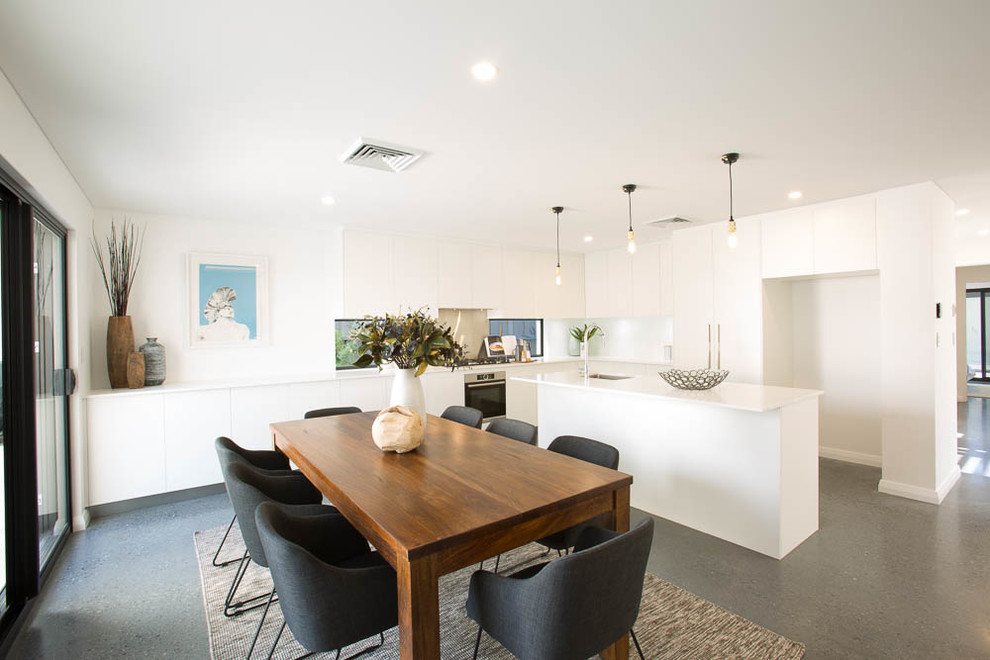 Inspiration pour une salle à manger ouverte sur la cuisine design de taille moyenne avec un mur blanc et un sol gris.