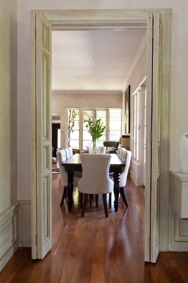 Foto di una grande sala da pranzo aperta verso la cucina chic con pareti beige e pavimento in legno massello medio