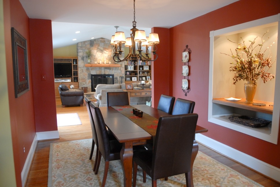 Cette photo montre une salle à manger moderne fermée et de taille moyenne avec un mur rouge et un sol en bois brun.