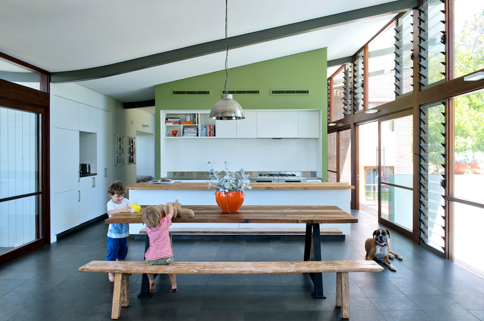 Esempio di una sala da pranzo aperta verso la cucina moderna con pareti verdi