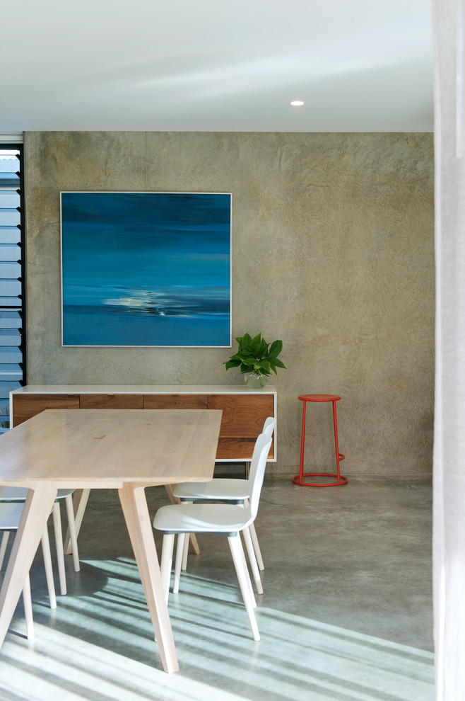 Immagine di una sala da pranzo aperta verso la cucina moderna di medie dimensioni con pavimento in cemento