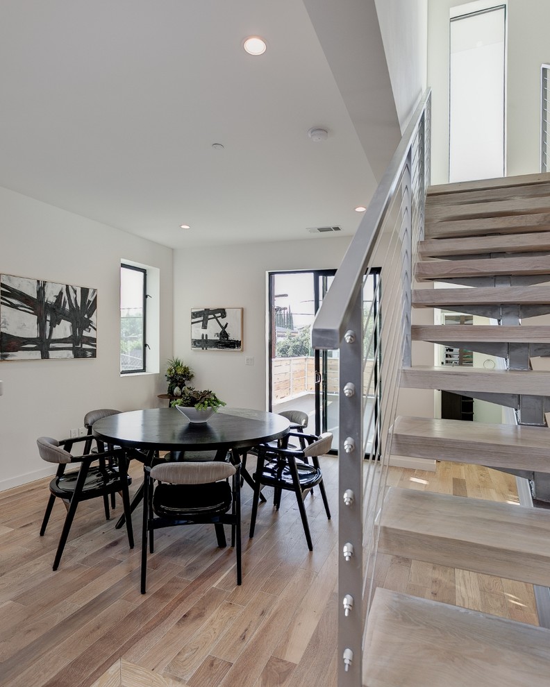 Mittelgroße Moderne Wohnküche ohne Kamin mit gelber Wandfarbe und hellem Holzboden in Los Angeles