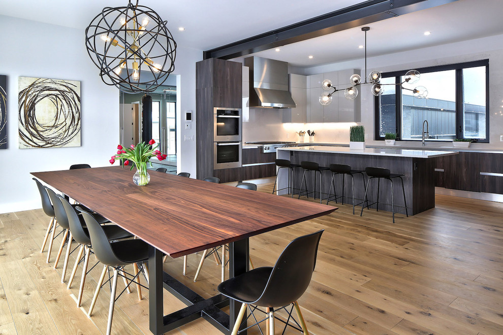 Große Moderne Wohnküche mit grauer Wandfarbe, Kaminumrandung aus Beton, braunem Holzboden, Tunnelkamin und braunem Boden in Toronto