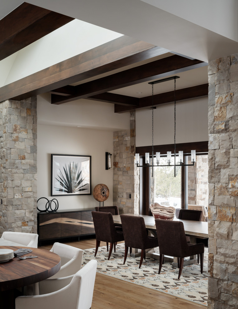 Esempio di una grande sala da pranzo aperta verso la cucina minimalista con pareti beige, pavimento in legno massello medio e travi a vista