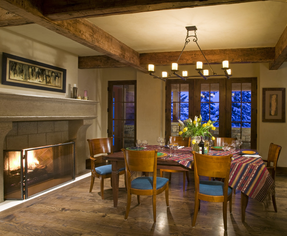 This is an example of a traditional dining room in Other with beige walls, dark hardwood flooring and a standard fireplace.