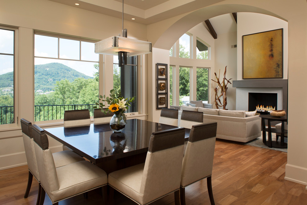 Esempio di una grande sala da pranzo aperta verso il soggiorno minimal con pareti beige e pavimento in legno massello medio