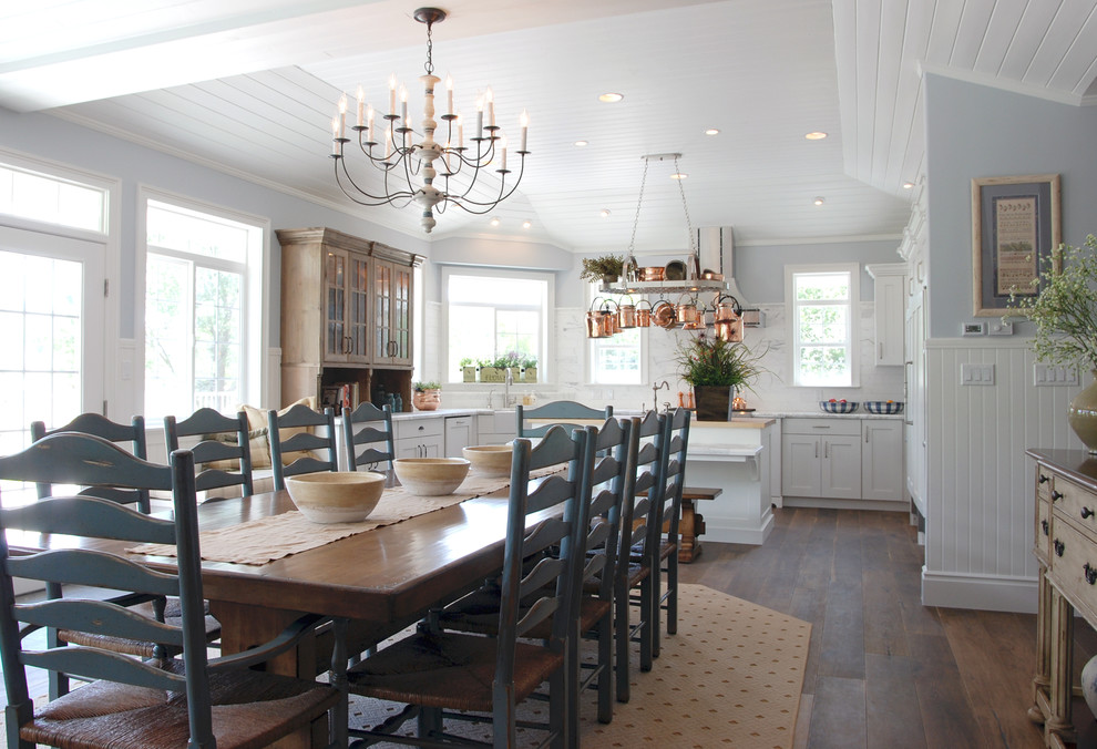 Ispirazione per una sala da pranzo aperta verso la cucina country con pareti blu e pavimento in legno massello medio