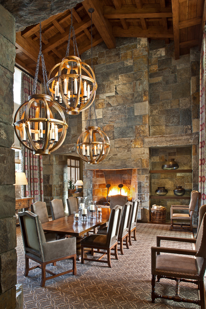 Exemple d'une salle à manger montagne avec une cheminée standard, un manteau de cheminée en pierre et éclairage.