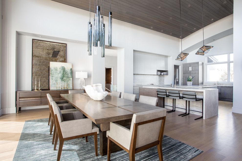This is an example of a contemporary open plan dining room in Salt Lake City with white walls, medium hardwood flooring and brown floors.
