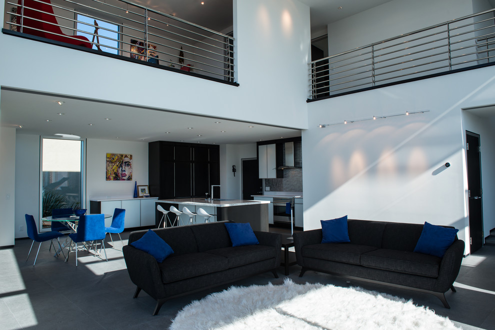 Immagine di una grande sala da pranzo aperta verso il soggiorno minimalista con pareti bianche e pavimento in gres porcellanato