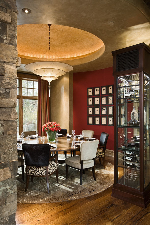 Inspiration pour une grande salle à manger chalet fermée avec un mur rouge, parquet foncé et un sol marron.