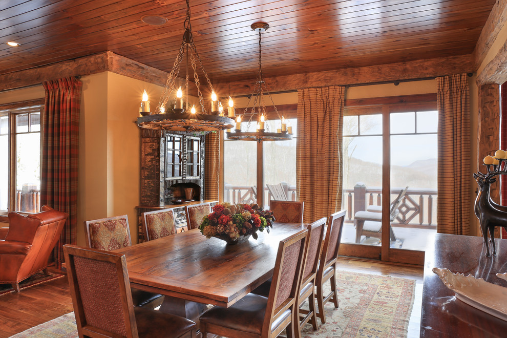 This is an example of a large rustic kitchen/dining room in Charlotte with yellow walls, medium hardwood flooring and brown floors.