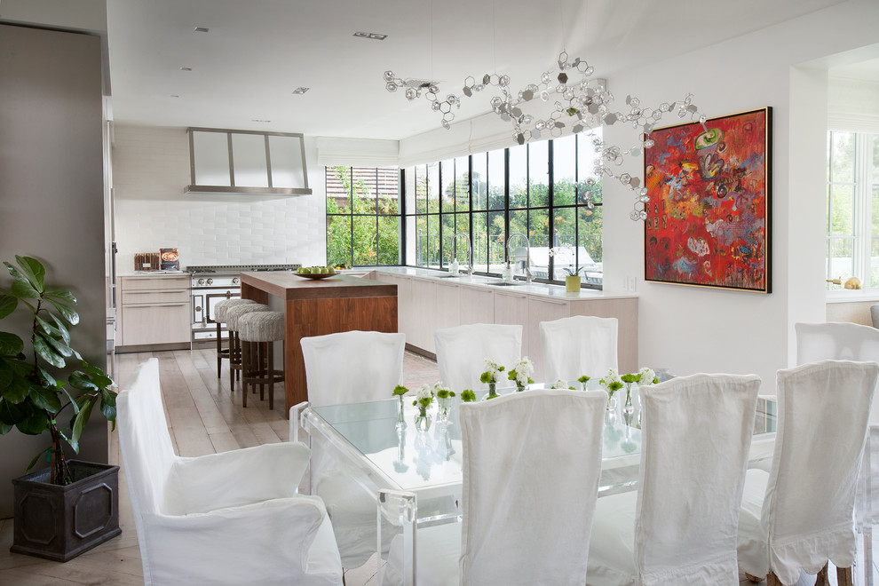 Foto di una sala da pranzo aperta verso la cucina tradizionale con pareti bianche e parquet chiaro