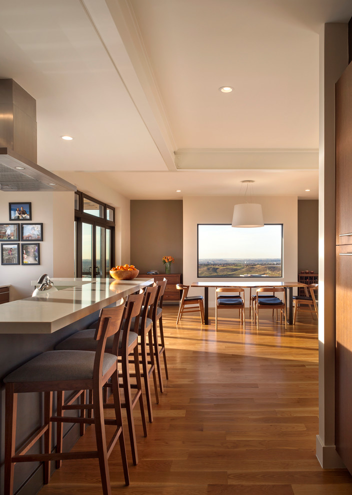 Example of a trendy medium tone wood floor and brown floor great room design in Denver with beige walls