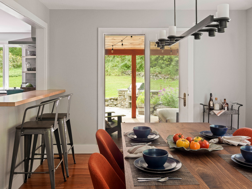 Exemple d'une salle à manger ouverte sur la cuisine chic de taille moyenne avec un mur gris et parquet clair.