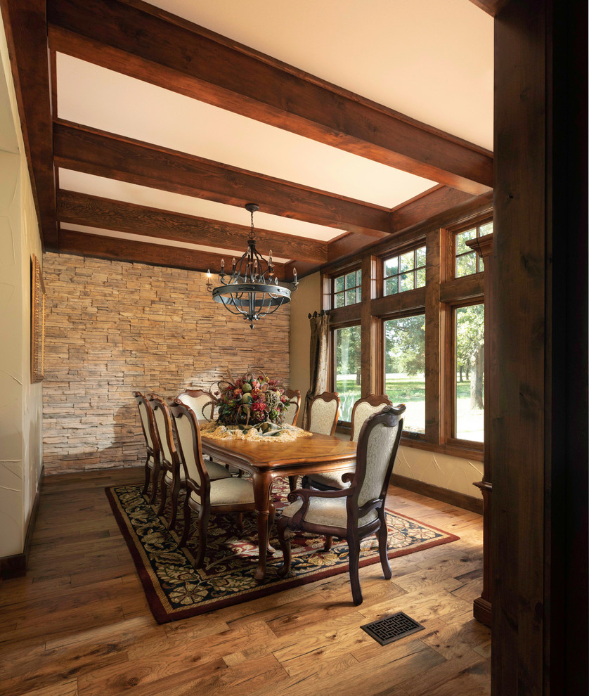 Large mountain style medium tone wood floor and brown floor enclosed dining room photo in Dallas with beige walls