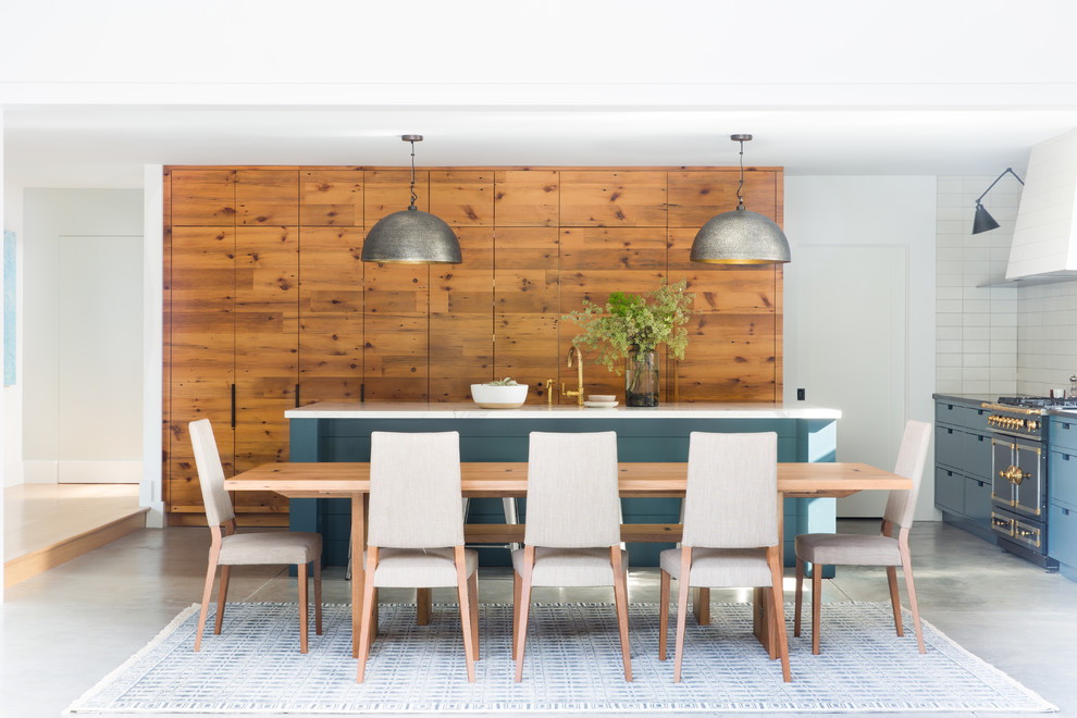 Esempio di una sala da pranzo aperta verso il soggiorno country con pareti bianche e pavimento in cemento