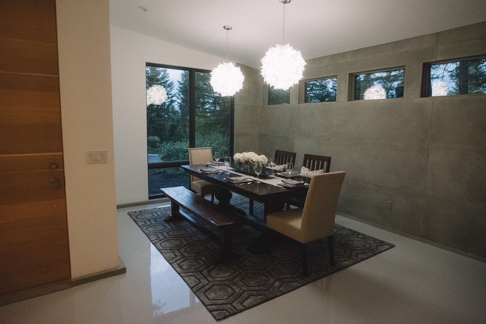 Large modern kitchen/dining room in Other with grey walls and concrete flooring.