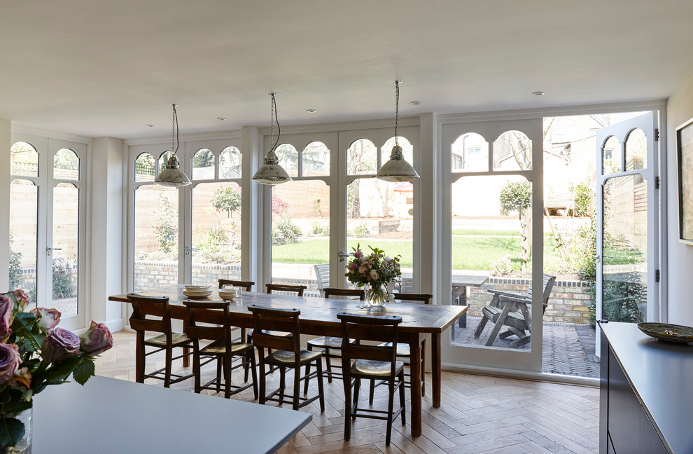 Immagine di una sala da pranzo aperta verso il soggiorno bohémian di medie dimensioni con pavimento in legno massello medio