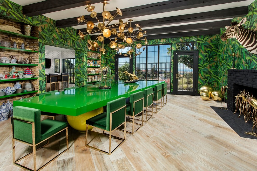 Idée de décoration pour une salle à manger design avec un mur vert, parquet clair, une cheminée standard et un manteau de cheminée en brique.