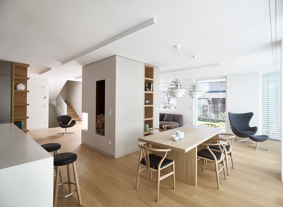 Стильный дизайн: гостиная-столовая в современном стиле с белыми стенами и светлым паркетным полом - последний тренд