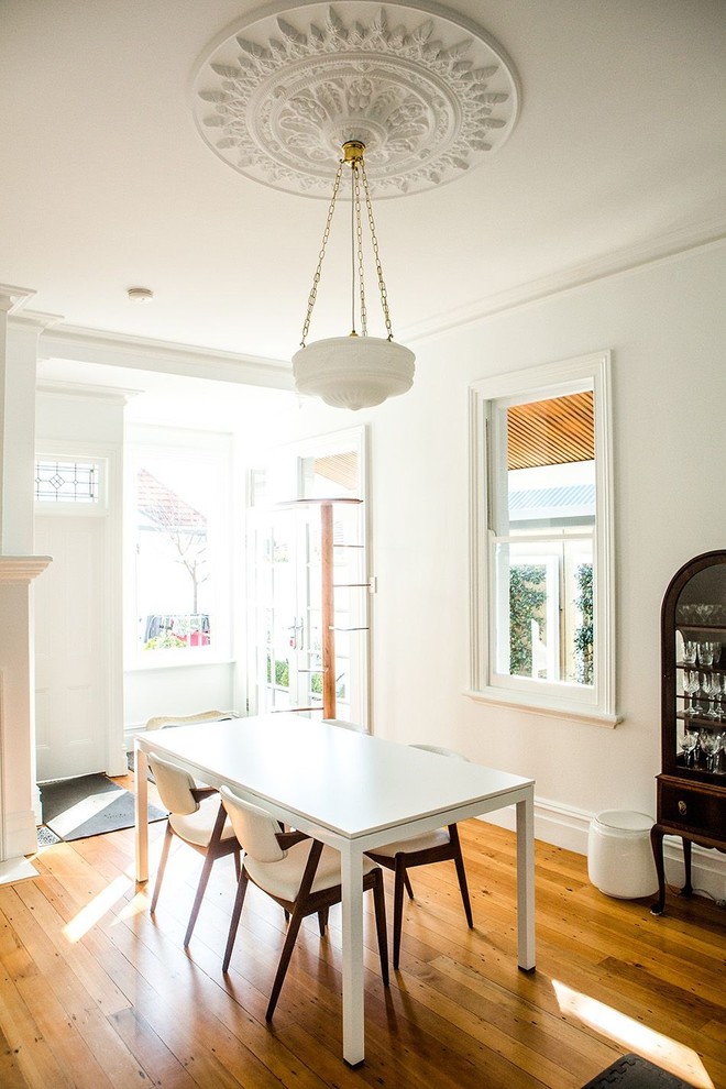 Esempio di una sala da pranzo design con pareti bianche e pavimento in legno massello medio