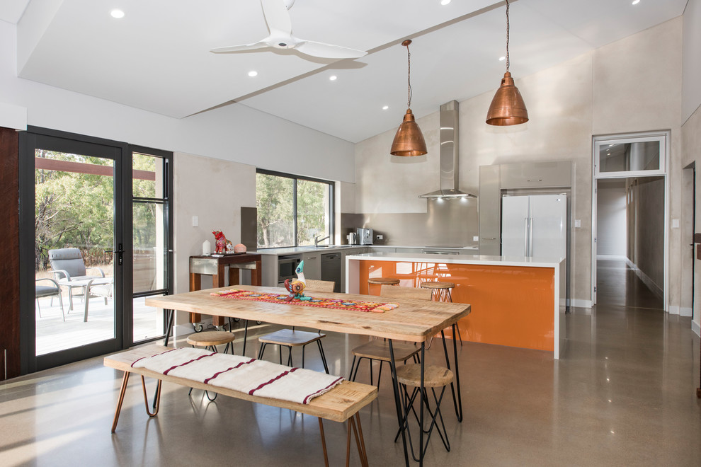 Réalisation d'une salle à manger ouverte sur la cuisine design avec un mur multicolore et un sol gris.