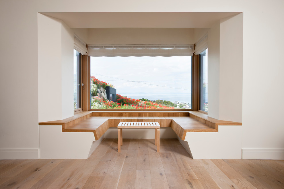 На фото: столовая в современном стиле с белыми стенами, светлым паркетным полом и бежевым полом с