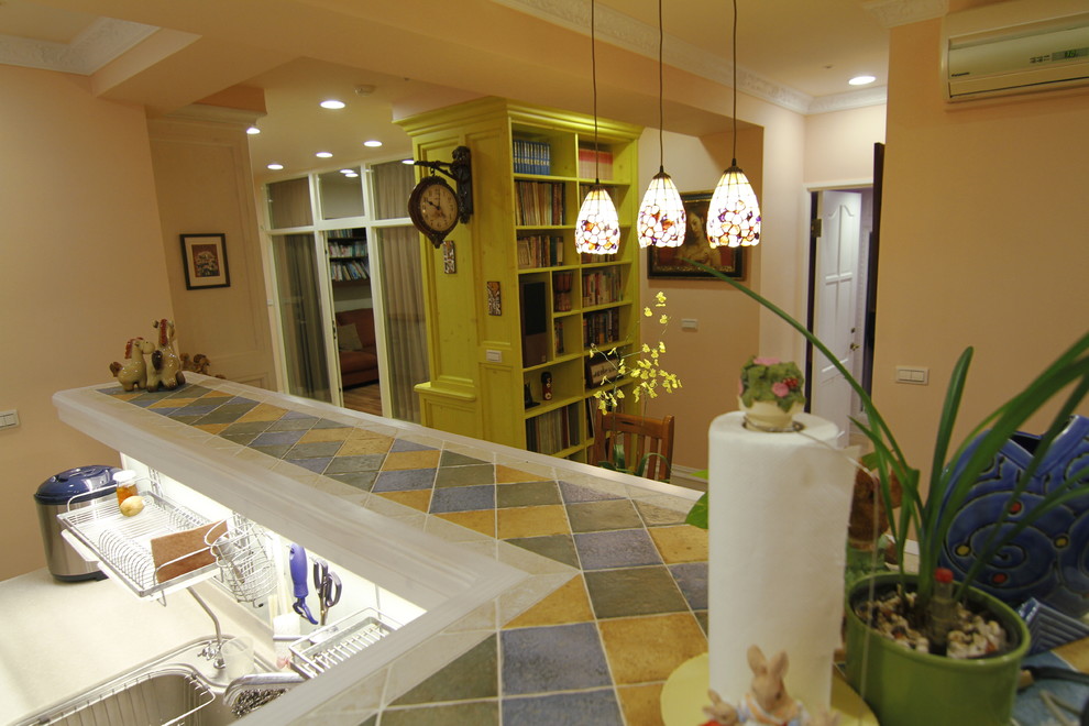 Esempio di una piccola sala da pranzo aperta verso la cucina stile rurale con pareti arancioni, pavimento in laminato, nessun camino e pavimento giallo