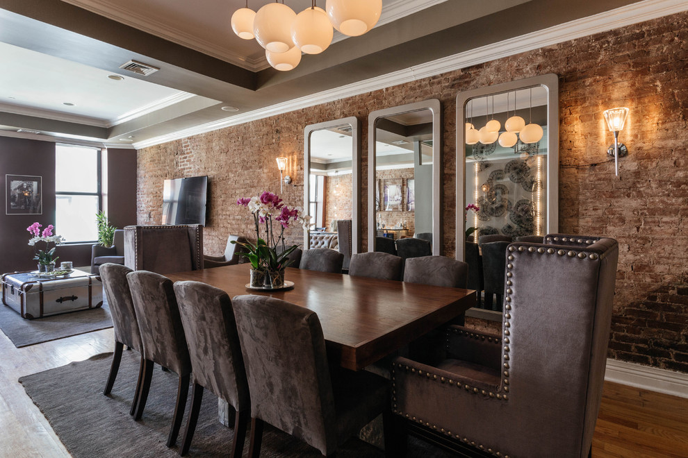Cette image montre une salle à manger ouverte sur la cuisine urbaine de taille moyenne avec un mur gris et un sol en bois brun.