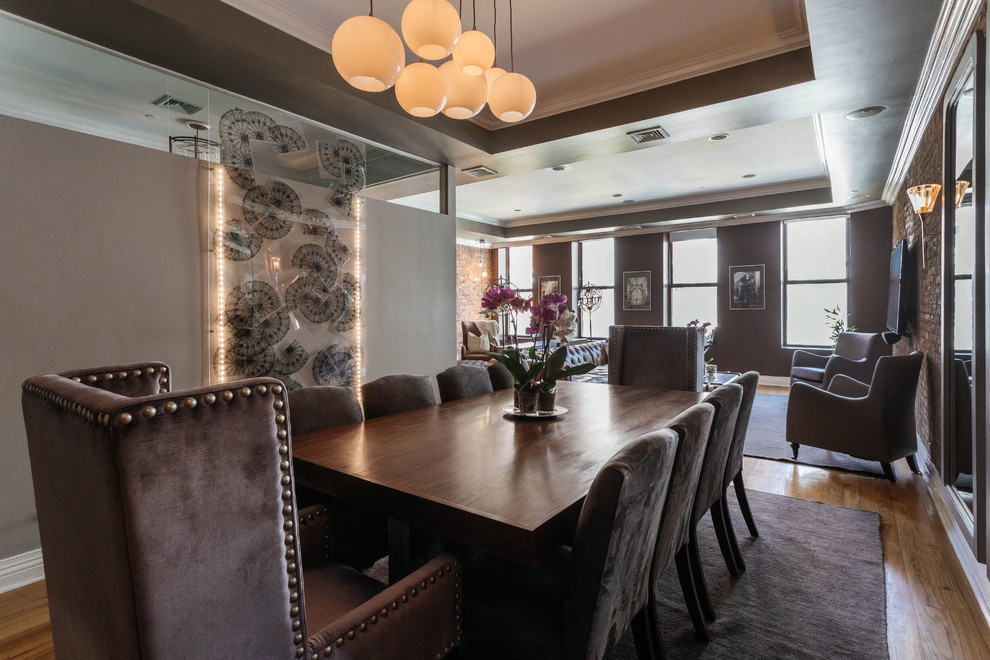Immagine di una sala da pranzo aperta verso la cucina industriale di medie dimensioni con pareti grigie e pavimento in legno massello medio