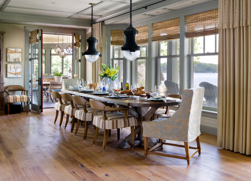 Example of a beach style medium tone wood floor dining room design in Other with beige walls