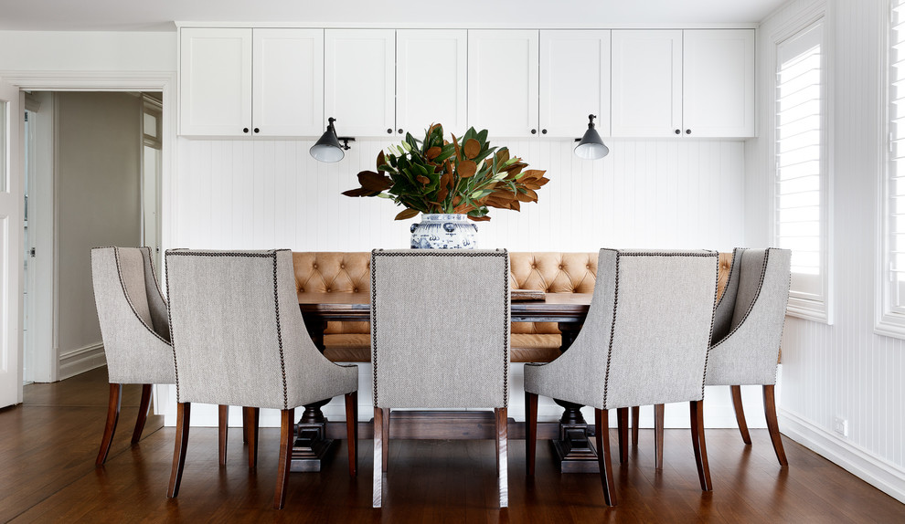 Inspiration pour une salle à manger ouverte sur la cuisine marine avec un mur blanc, parquet foncé et un sol marron.