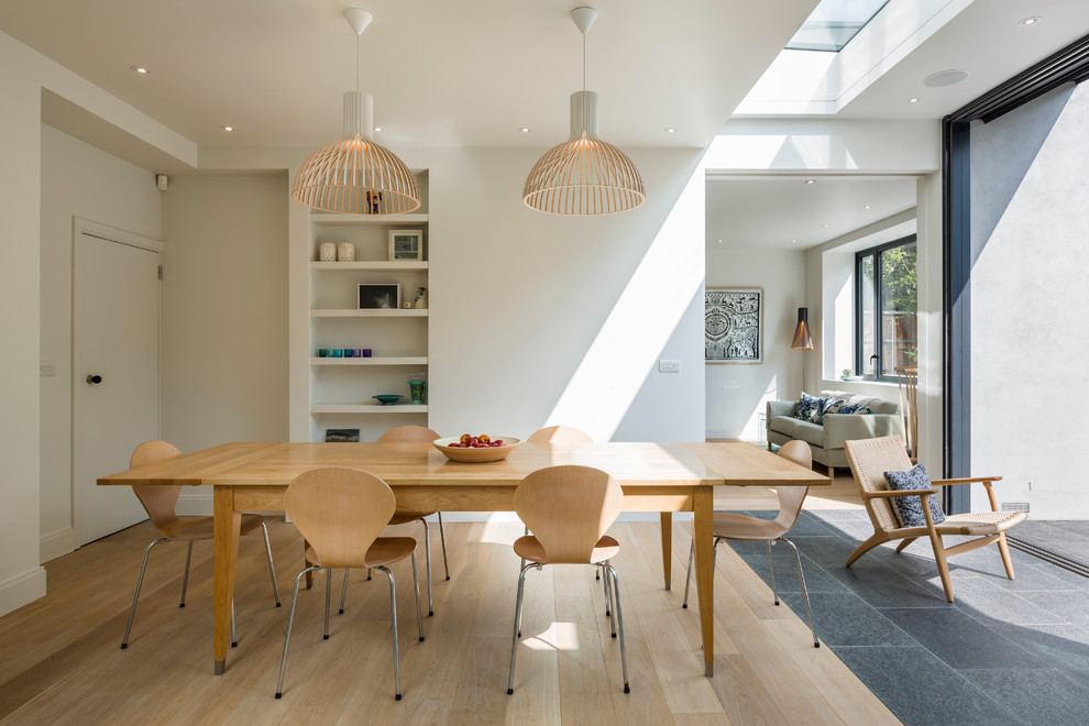 Réalisation d'une salle à manger nordique avec un mur blanc et parquet clair.